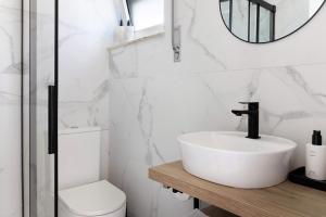 un bagno con lavandino, WC e specchio di My Beach House Esposende a Esposende Altre 19 foto
