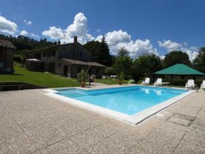 a swimming pool in front of a house at Scappo in Umbria, Casale Piccino in Collicello