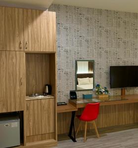 a desk with a red chair and a television at Her Home Spa Motel Douliu in Douliu