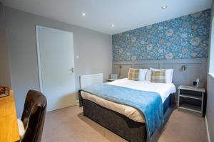 a bedroom with a bed with a blue wall at The Midland Hotel in Leeds