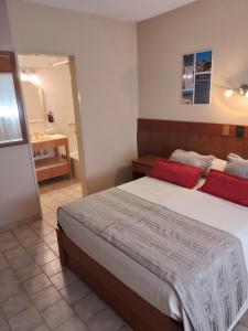 a bedroom with a large bed and a bathroom at Camino Real Hotel in Córdoba