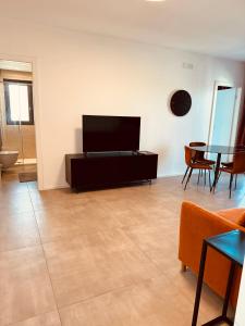 巴里Marisabella Suite 6的带电视和桌子的客厅