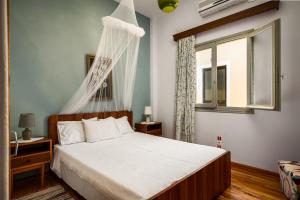 um quarto com uma cama e uma janela em Agaloula Centrally Located Apartments by Konnect, Lakka em Lákka