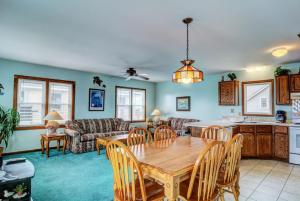 a living room with a wooden table and a kitchen at Hoff 1 in Topsail Beach +39 photos