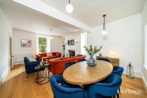 a living room with a table and blue chairs at Kirkton Family Farmhouse with Hot Tub, Alford, Aberdeenshire in Alford