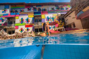 una mujer en una piscina con un edificio lego en Pousada das Galinhas, en Porto de Galinhas
