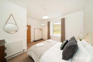a bedroom with a large white bed with a mirror at Kirkton Family Farmhouse with Hot Tub, Alford, Aberdeenshire in Alford