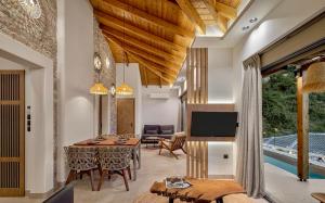 a living room with a table and a tv at Villa Vrachos luxury Living in Vrachos