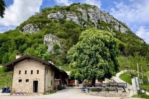a small building in front of a mountain at Baita Lomasona in Comano Terme