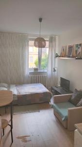 a bedroom with two beds and a couch and a window at Night Host Krakowska 3/1 in Bytom