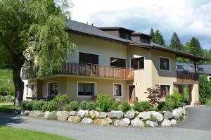 een groot geel huis met een balkon bij Rauterhof in Hermagor