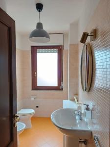a bathroom with a sink and a toilet and a window at La Casina in Sassari