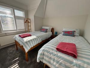 een slaapkamer met 2 bedden en een raam bij Holywell Apartments in Eastbourne