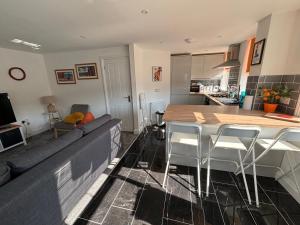 een keuken en een woonkamer met een tafel en stoelen bij Holywell Apartments in Eastbourne