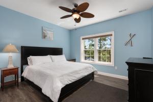 a bedroom with a bed and a ceiling fan at Voyage Anchor in Nags Head +66 photos