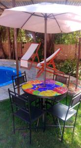 a table with an umbrella next to a pool at Cabaña en Valle de Elqui in Horcon