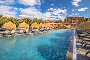 聖米格爾德阿沃納的住宿－Barceló Tenerife，度假村的游泳池配有椅子和遮阳伞