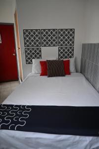 1 dormitorio con 1 cama grande y puerta roja en Hotel La Colección, Universidad de Guanajuato, Centro, en Guanajuato