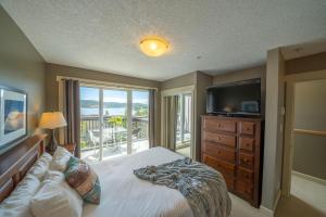 a bedroom with a bed and a flat screen tv at Sooke Harbour Resort & Marina in Sooke