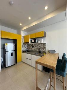 a kitchen with a wooden table and a refrigerator at Apartaestudio en Pozos Colorados in Playa Bello Horizonte