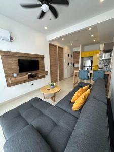 a living room with a blue couch and a tv at Apartaestudio en Pozos Colorados in Playa Bello Horizonte