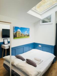 a bedroom with a bed with blue and white walls at Sun Guest House Cambridge in Cambridge