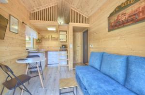 a living room with a blue couch and a table at Domek Cud Miód in Wisła