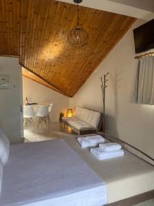 a bedroom with a bed and a couch and a table at Sea Side Studios in Agia Effimia