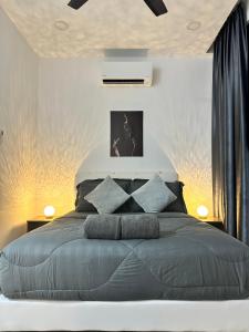 een slaapkamer met een groot bed met blauwe kussens bij ITCC Manhattan Suites by AURORA in Penampang