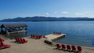 a group of chairs sitting on a dock on a lake at The Stone Gate Resort in Lake George