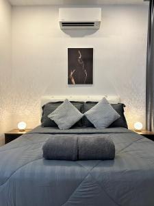 een slaapkamer met een groot bed met 2 kussens bij ITCC Manhattan Suites by AURORA in Penampang