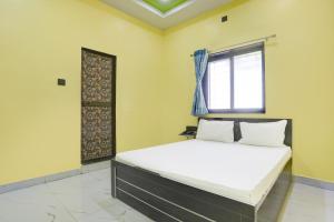 a bedroom with a bed and a window at OYO Hotel Raj Guest House in Akola