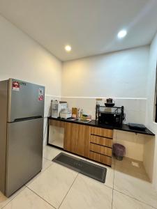 a kitchen with a refrigerator and a counter at ITCC Manhattan Suites by AURORA in Penampang