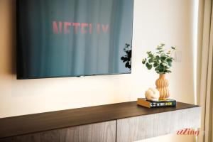 a television on a wall with a vase on a book at Exclusive Luxury at Mercury Towers in St Julian's