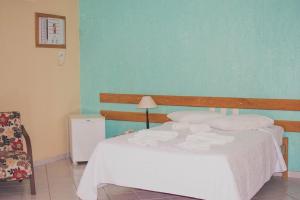 - une chambre avec un lit blanc et un mur bleu dans l'établissement Costa Marlin Hotel, à Guriri