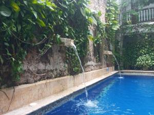 a swimming pool with a water fountain at Casa Pizarro Hotel Boutique in Cartagena de Indias