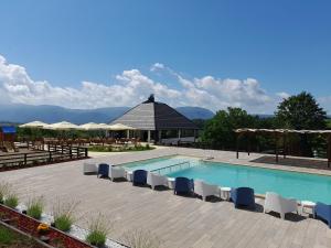 uma piscina com cadeiras e um gazebo em Horizonti em Vrmdža