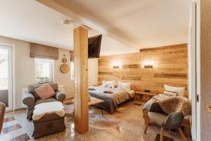 a bedroom with a bed and a couch and chairs at Pension Goldbachmühle in Blankenburg