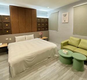 1 dormitorio con 1 cama grande y 1 sofá en Her Home Spa Motel Douliu en Douliu