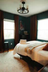Historic Renovated 2BD - Overlooking Downtown في نوكسفيل: غرفة نوم بسرير بجدران خضراء وثريا