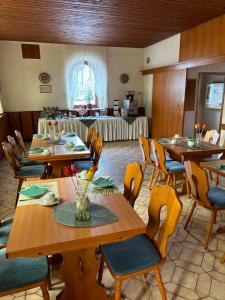 uma sala de jantar com mesas e cadeiras de madeira em Goldener Loewe em Wunsiedel