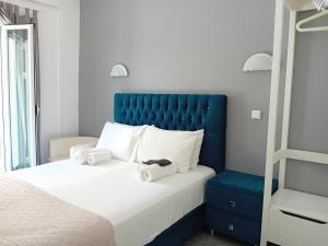帕爾加的住宿－Studios Spiros Parga，一间卧室配有一张大床和蓝色床头板