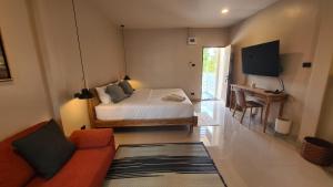 VNL Stay في ترانغ: غرفة نوم بسرير وتلفزيون وأريكة