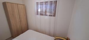 een kleine slaapkamer met een bed en een raam bij Vela Vrata in Cres
