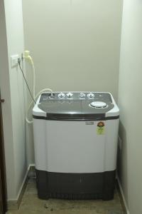 a small stove in a corner of a room at NR HEAVENZ Near Rajagiri Hospital in Alwaye