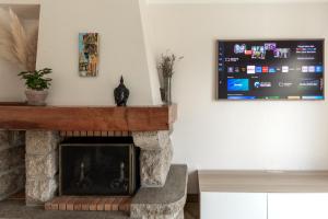 アラドンにあるVilla au calme absolu - à 200 m du Golfeの暖炉とテレビのあるリビングルーム