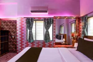 a bedroom with a bed with a pink lighting at Super OYO Cozee Homestay and Guest House in Kolkata