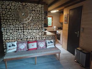 a living room with a bench and a wall with logs at Chalet L'envolée Bleue in Xonrupt-Longemer