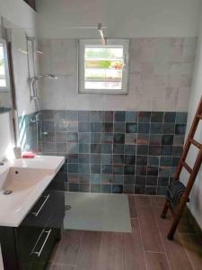 une salle de bain avec un lavabo et une fenêtre dans l'établissement Villa zen Bali piscine privée 3 chambres lotissement les hauts de la vallée d'or, à Saint-François