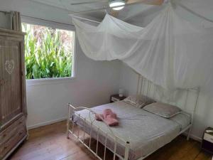 - une chambre avec un lit à baldaquin et une fenêtre dans l'établissement Villa zen Bali piscine privée 3 chambres lotissement les hauts de la vallée d'or, à Saint-François 10 autres photos